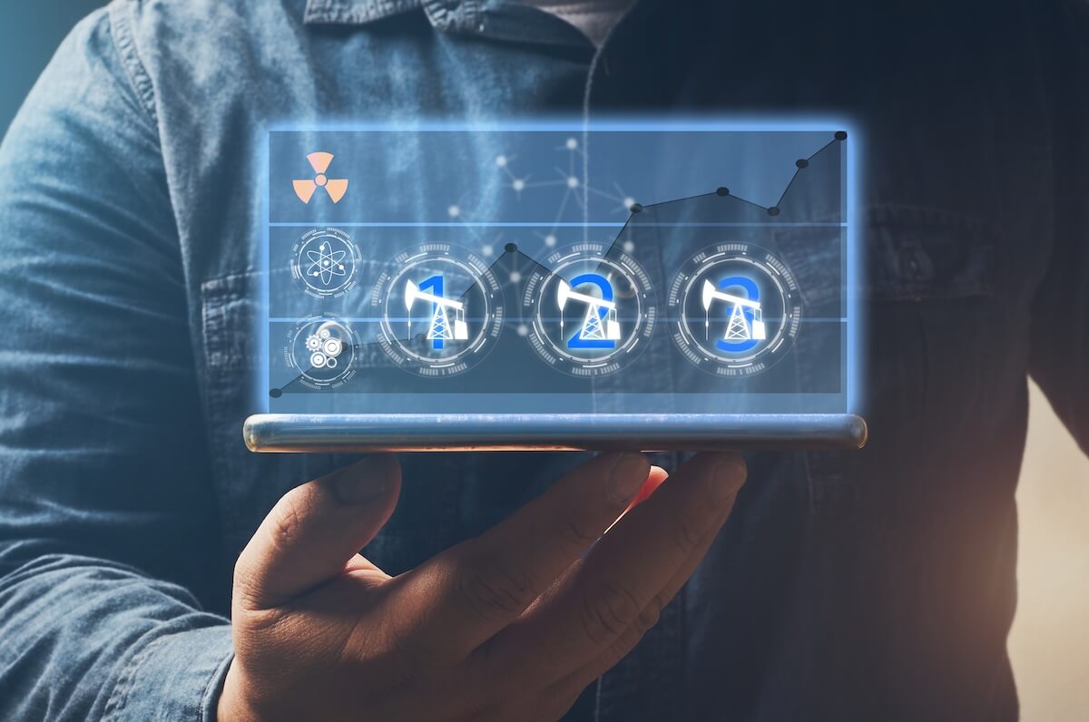A person holding a smartphone with glowing digital icons of oil derricks and data growth charts.