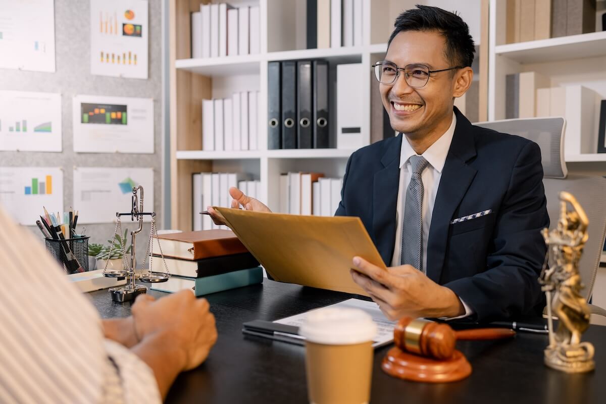managed-it-services-law-firms-midland Smiling attorney in a law office reviewing legal documents at a desk, representing managed IT support and cybersecurity services for law firms in Midland and Odessa.
