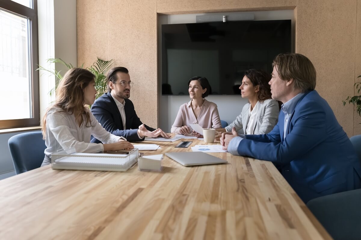 insurance-agency-managed-it-consulting-meeting IT consulting team reviewing technology strategy options with insurance agency leaders in a modern conference room.