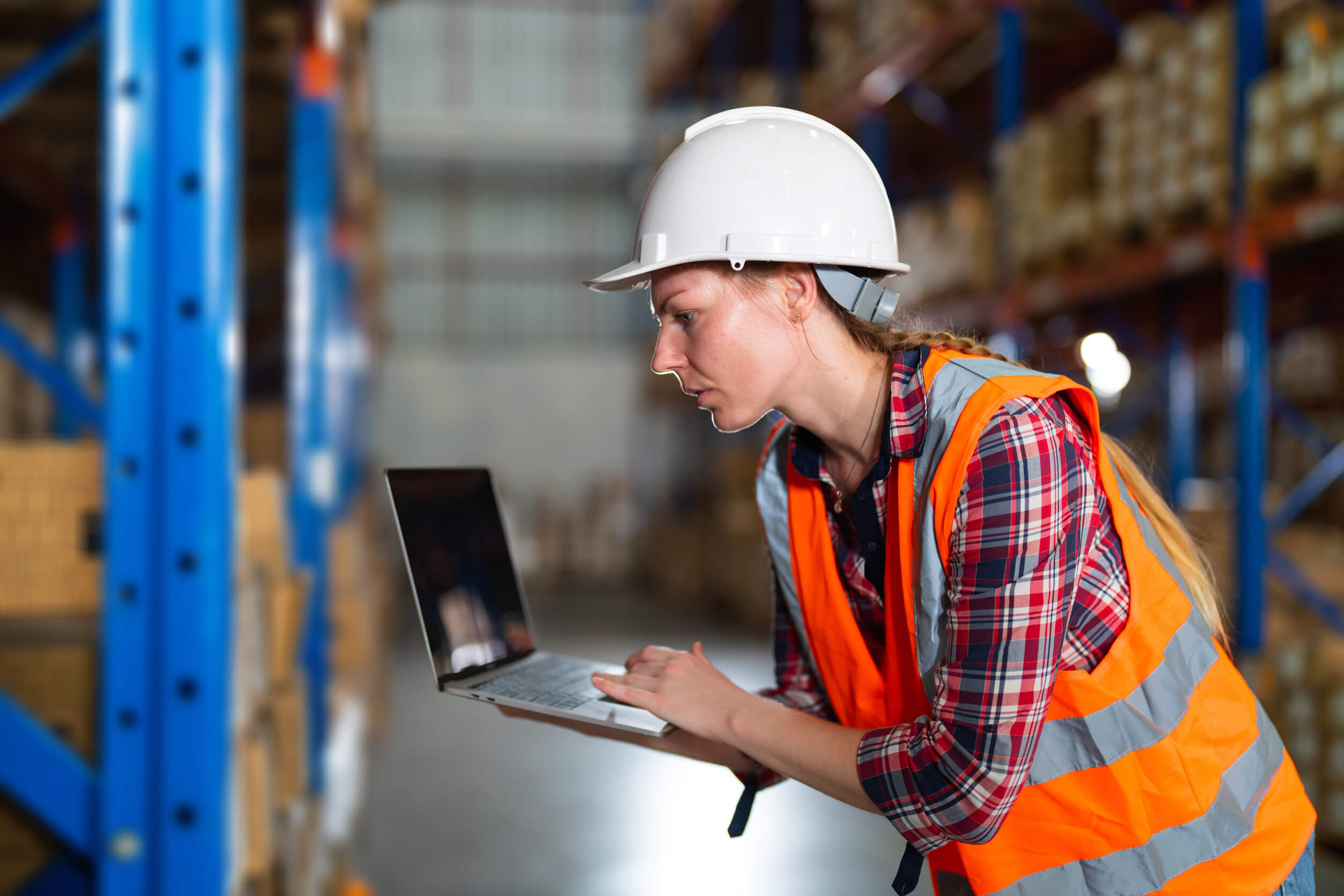 supply-house-managed-it-services Supply house employee using a laptop in a warehouse